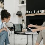 Astrolog i młoda kobieta analizują horoskop na ekranie laptopa