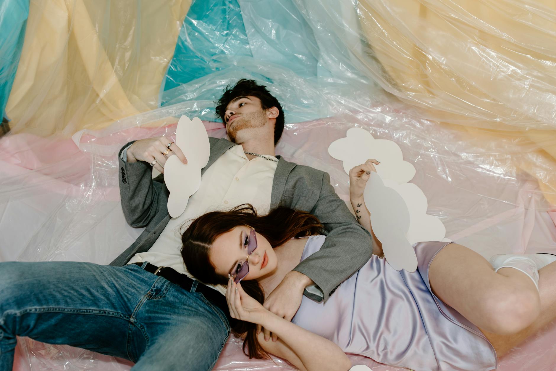 Para odpoczywa w domu na tle kolorowych chmur z papieru