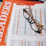 Okulary na dokumentach finansowych z danymi do analizy budżetu