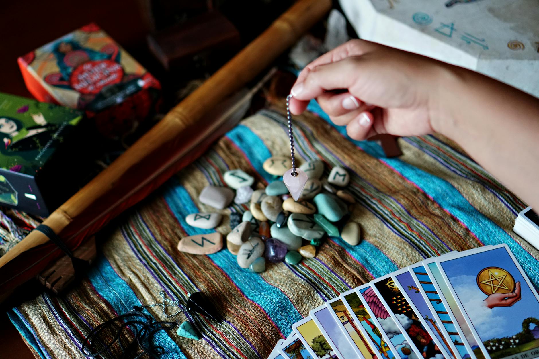 Stół do wróżenia z rozłożonymi runami, kartami tarota i wahadełkiem