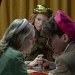 Wróżka kładzie karty tarota przed zaciekawioną parą w półmroku