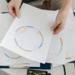 Dłonie trzymające astrologiczne wykresy i horoskopy